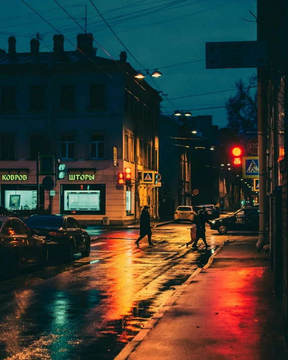 people walking in the rain at night in a city