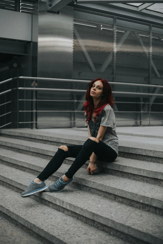 a woman sits on some steps in a building