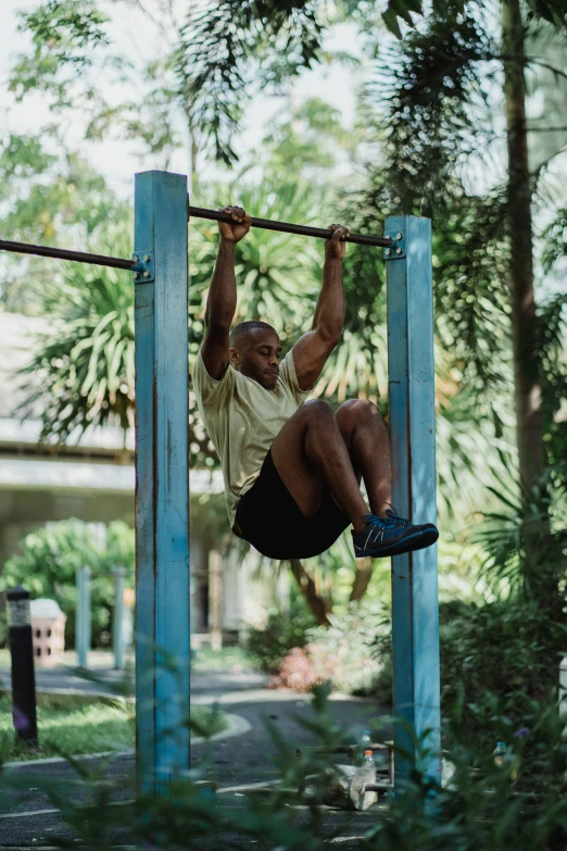 a man performs a pull - up as part of the crossfit course