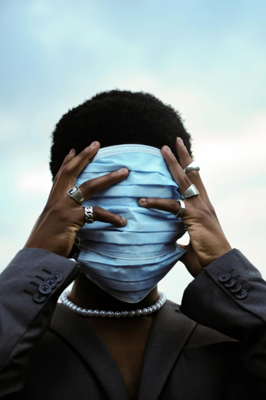 woman with a mask covering her face by hand