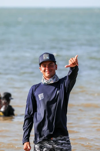 man on the beach giving a peace sign