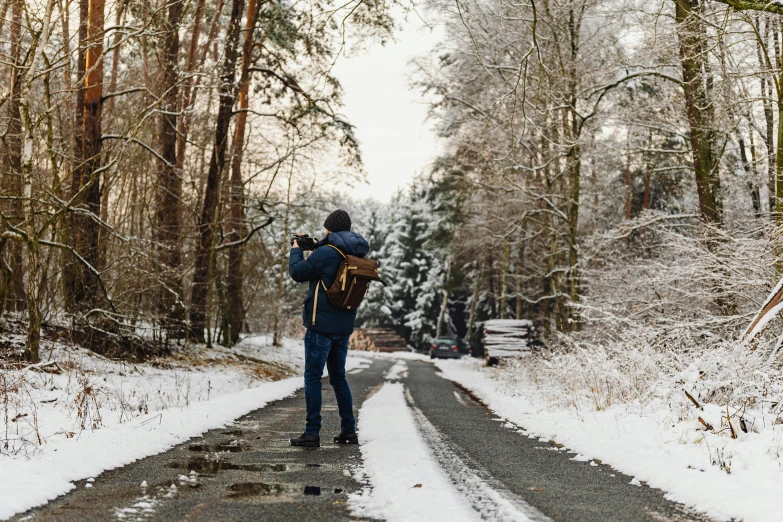 a person with a camera takes pictures of snow and trees