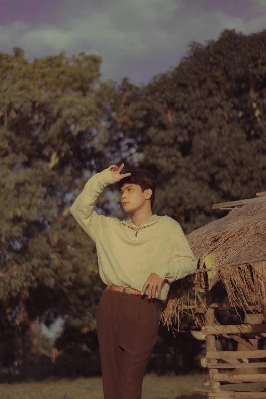 a man standing near a wooden pole near a forest