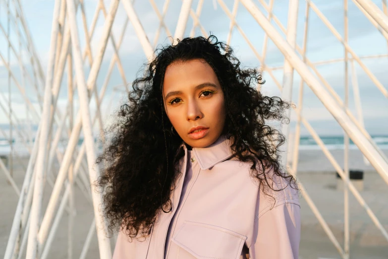 a woman with a curly hair standing in front of a white wire