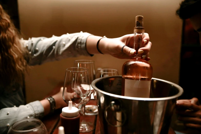 woman pouring wine into a silver glass on a table