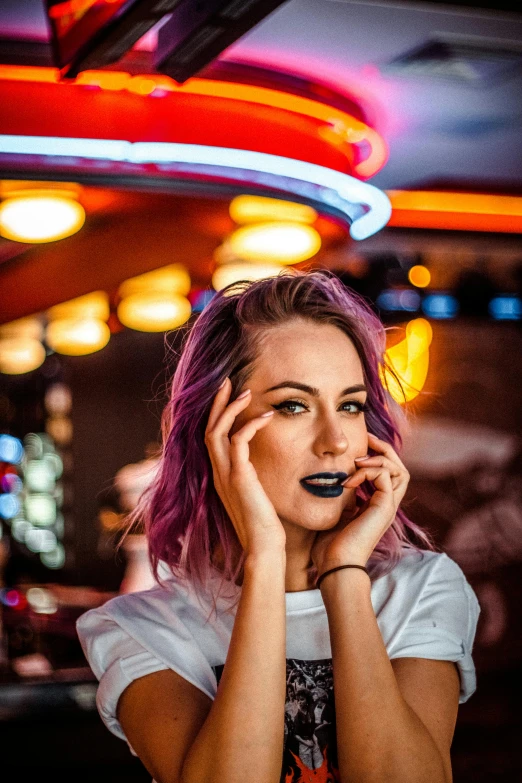 a woman with pink hair wearing makeup looking to her right