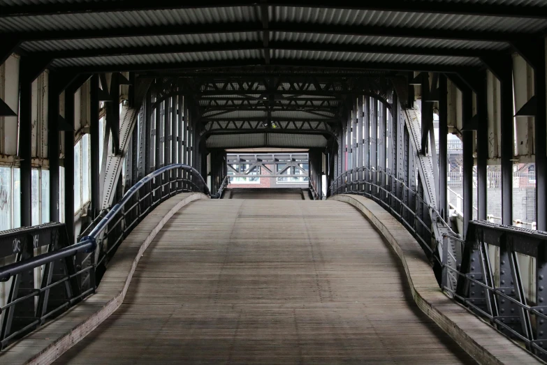 a long bridge has a metal fence across the side