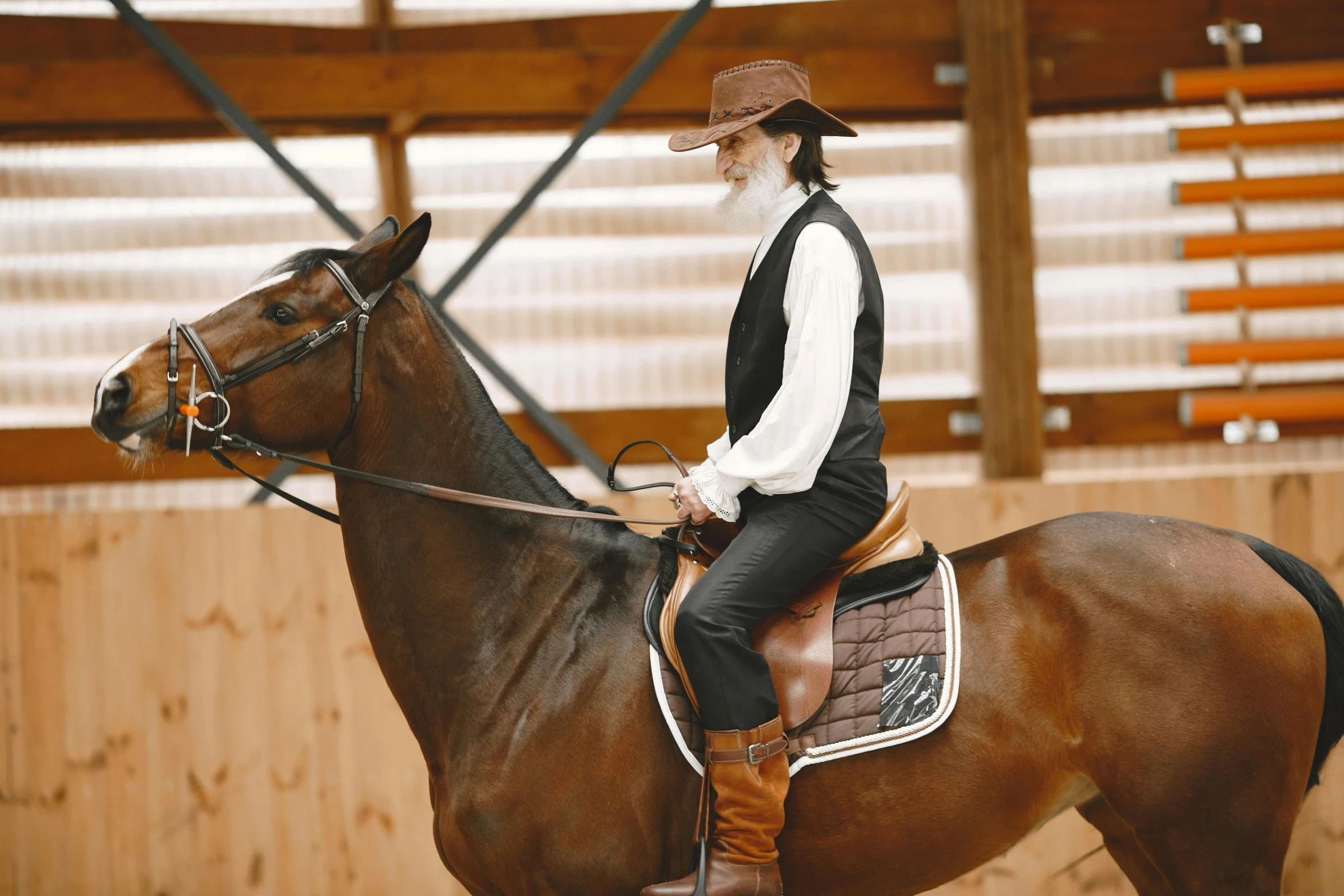 a man on a horse in an indoor arena