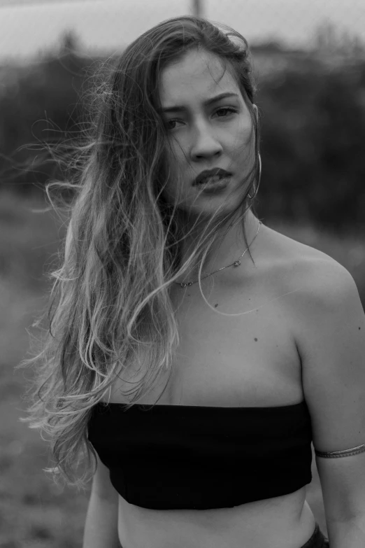 a woman with long hair standing on a field