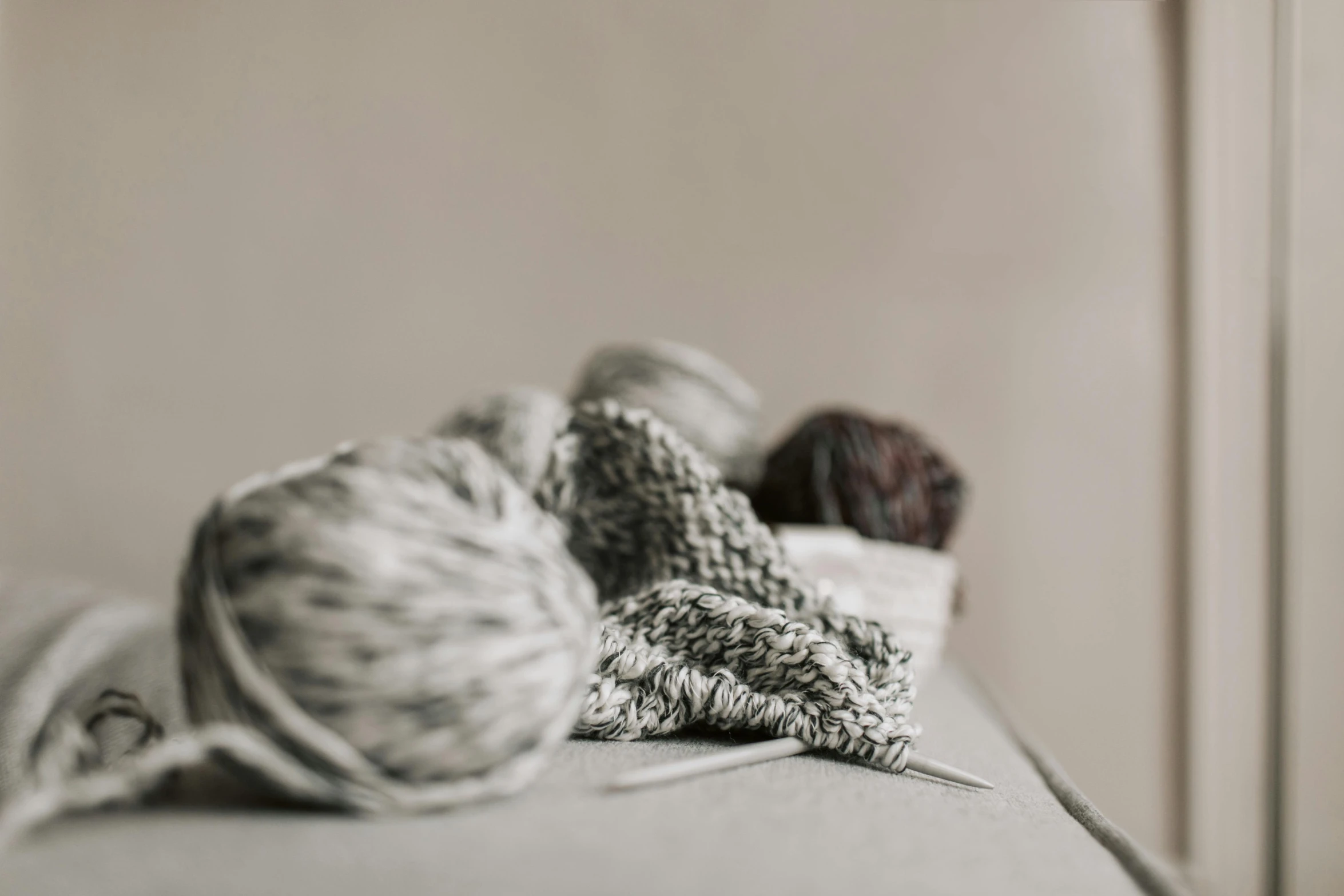 three balls of yarn are on top of the couch