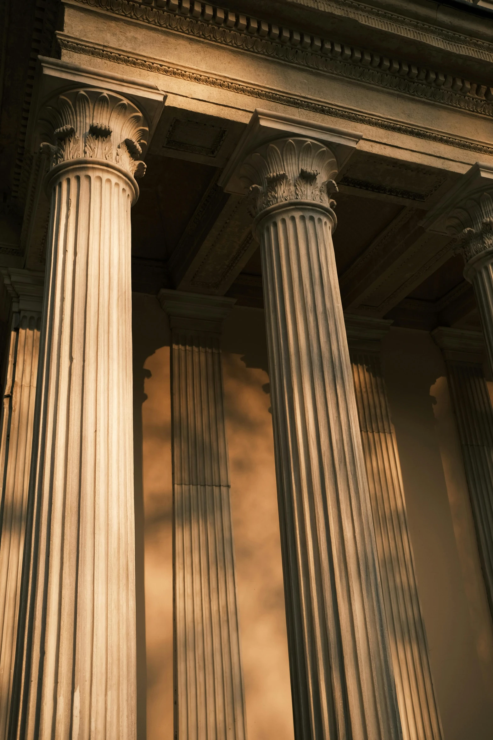 two ancient pillars in a row, with the light from the sun behind them