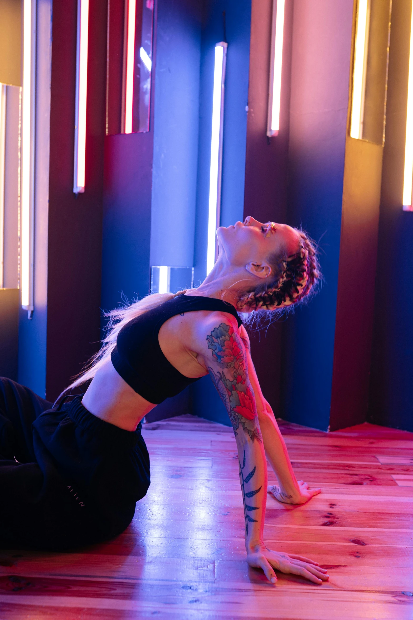 a woman in a black top is stretching on the floor