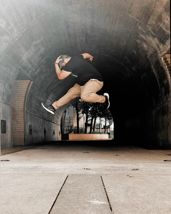 a man jumps in the air in an underpass