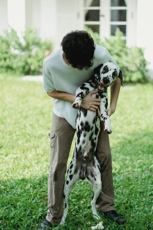 a man holding a dalmatian in his hands