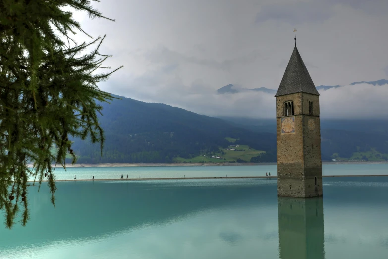 a water clock tower is reflecting the sky and mountain