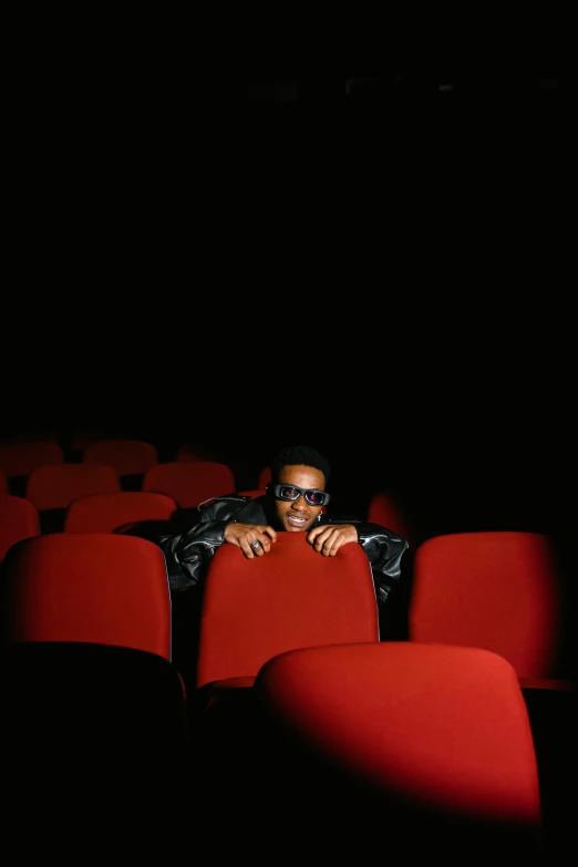 a man sitting in an empty theater seat