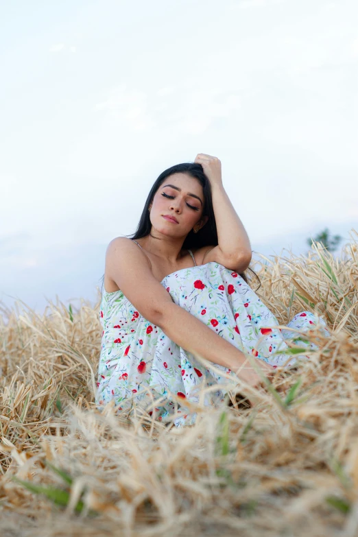 a woman is sitting in a field of tall grass