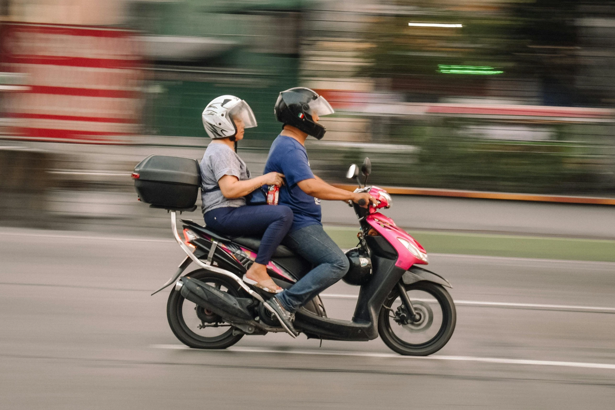 the couple is riding their motorcycle down the street