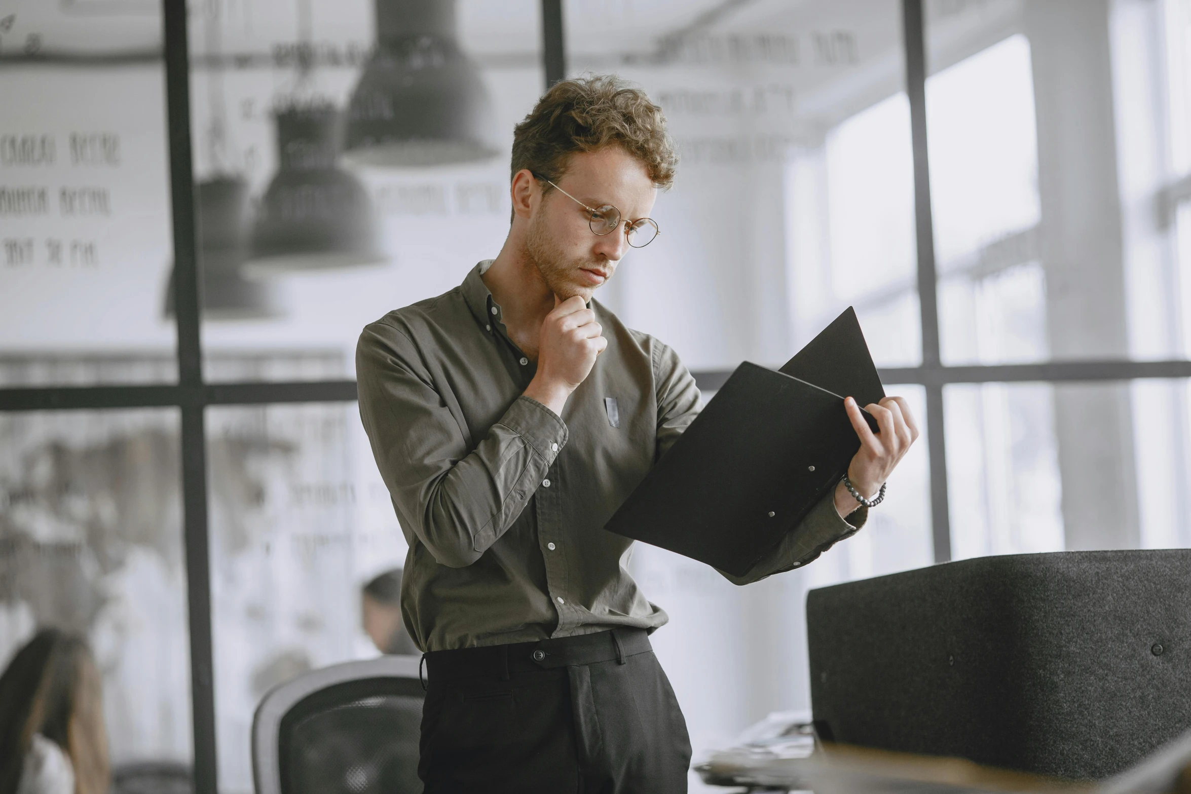 a man in glasses looking at a piece of paper