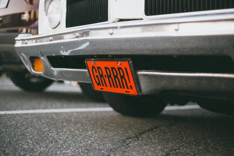 two black and silver vehicles and a orange street sign