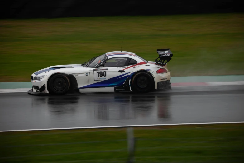 a white race car driving on the track