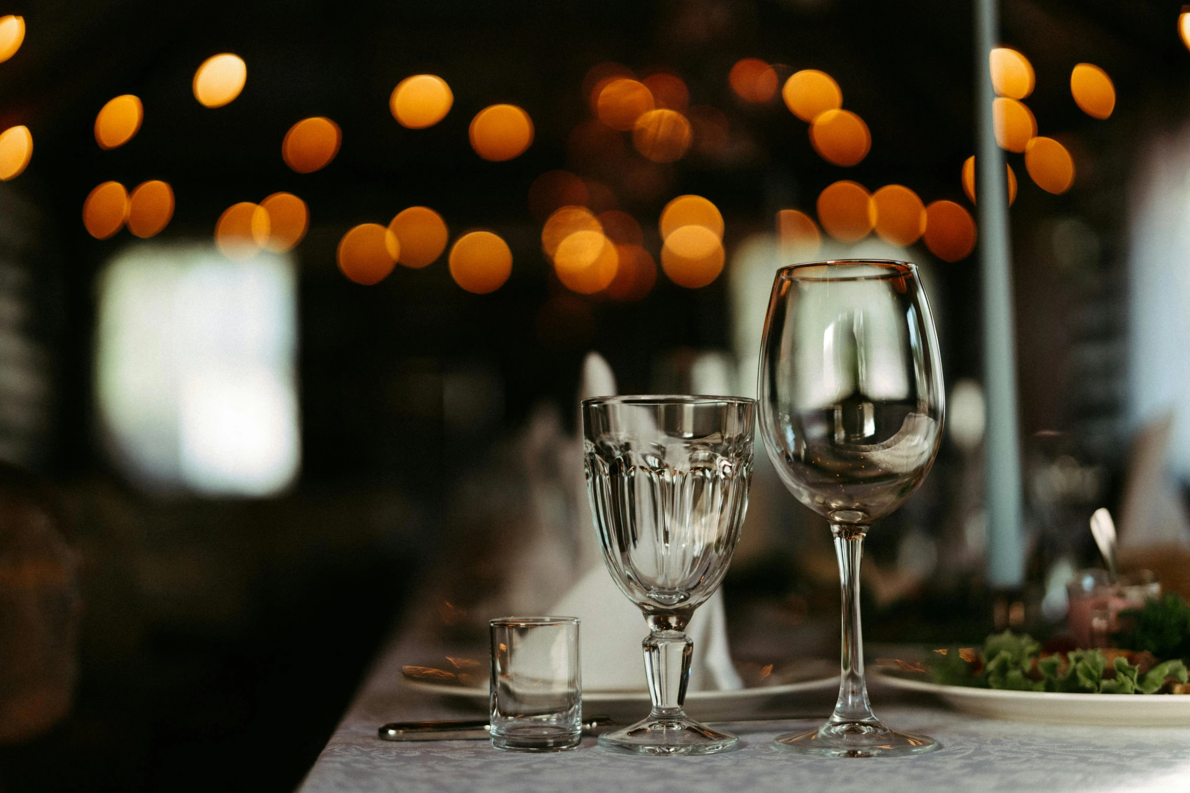 a table set up with champagne flutes and plates