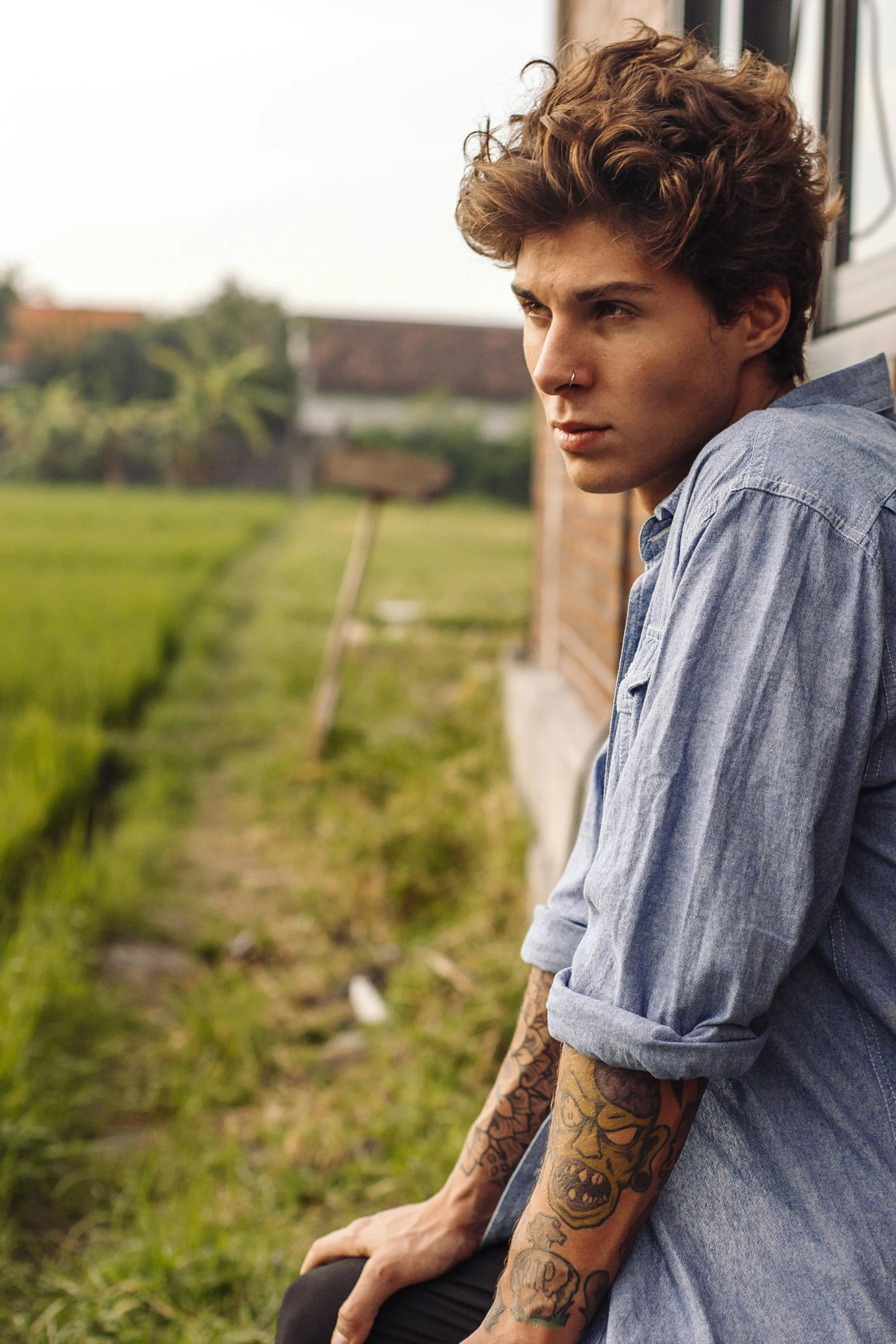 a man is sitting in a train next to some grass