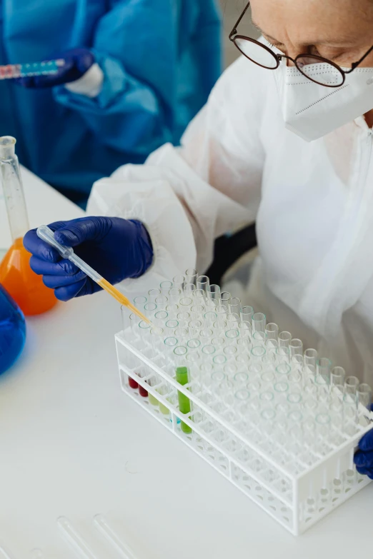 a person with safety glasses and gloves doing a experiment