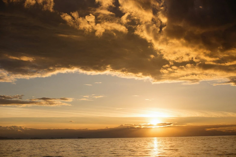 a beautiful sunset over a calm ocean and hills