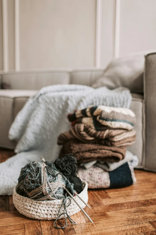 a pile of sweaters sitting on top of a wooden floor