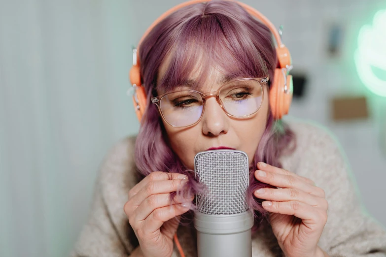 a woman in headphones is holding up a microphone