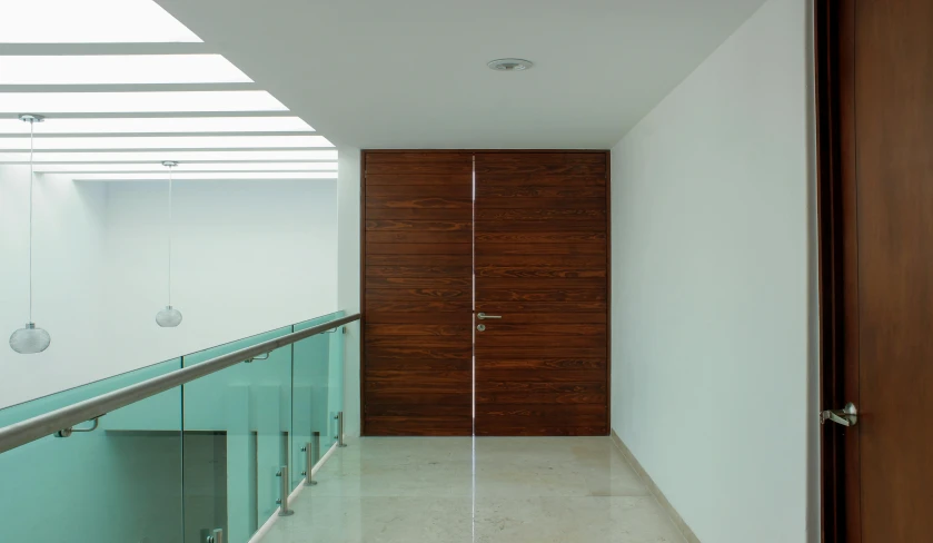 a hallway with glass balustoms and wooden door