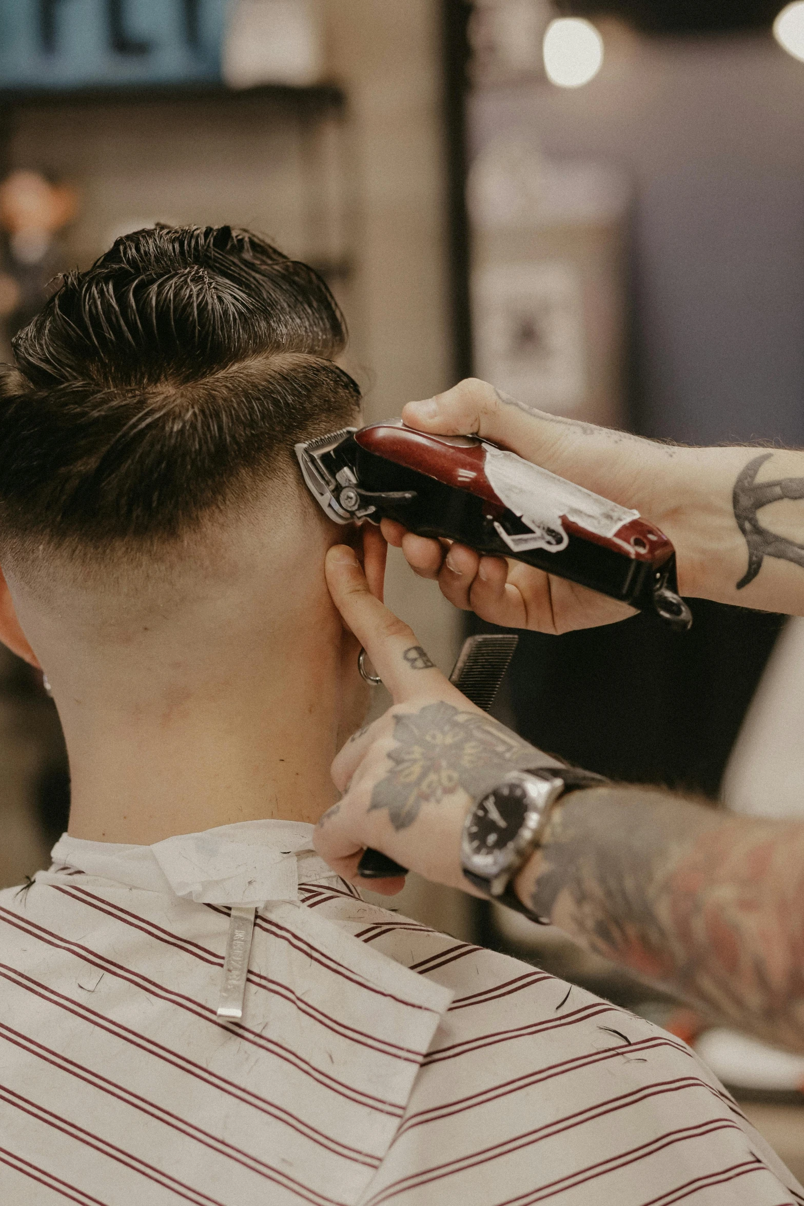 a close up view of a barber doing a man's hair