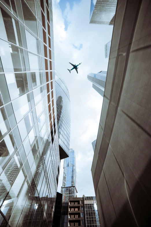 a passenger jet flying above some large skyscrs