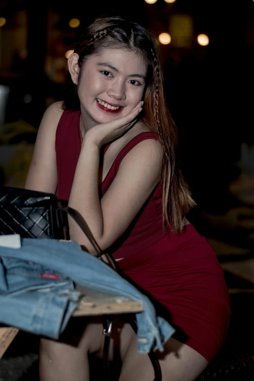 a smiling woman posing with some clothes in a room