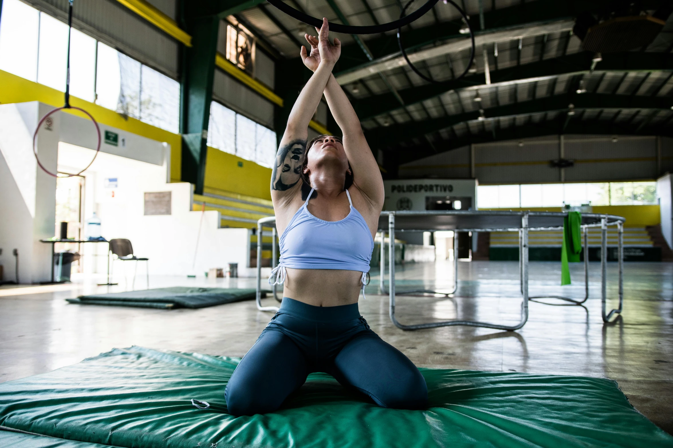 the woman practices yoga on a mat in the gym