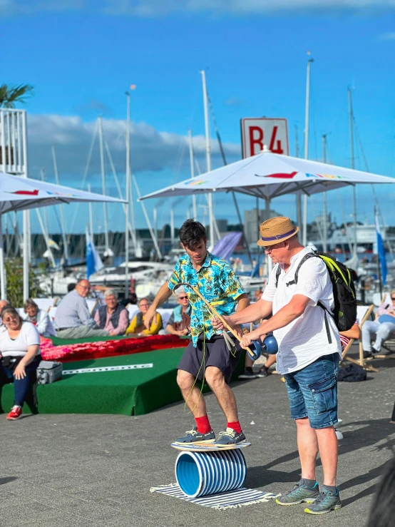 two people performing tricks on a skate board at a carnival