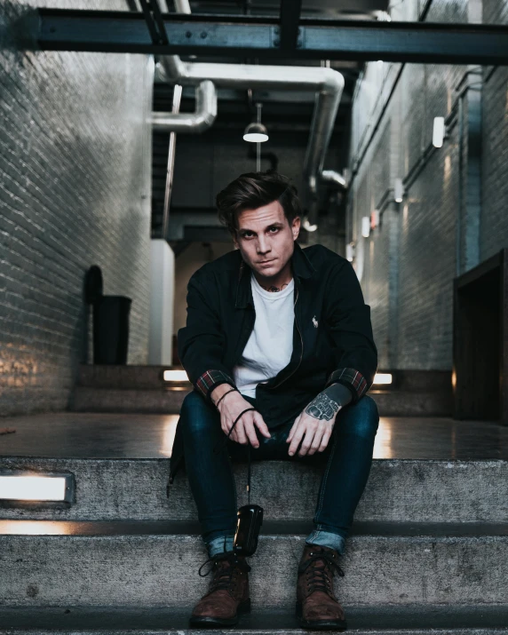 a man sits on a step in an industrial building