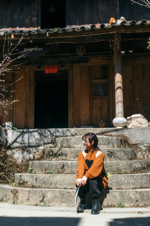 a woman sitting down on the street with her foot on the stairs