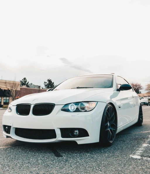 white bmw car parked in the middle of a parking lot