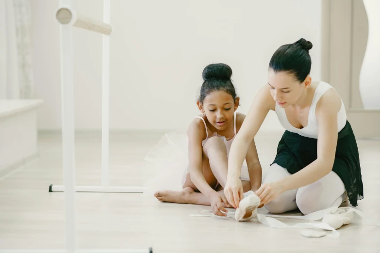 two girls with white dresses playing on the floor