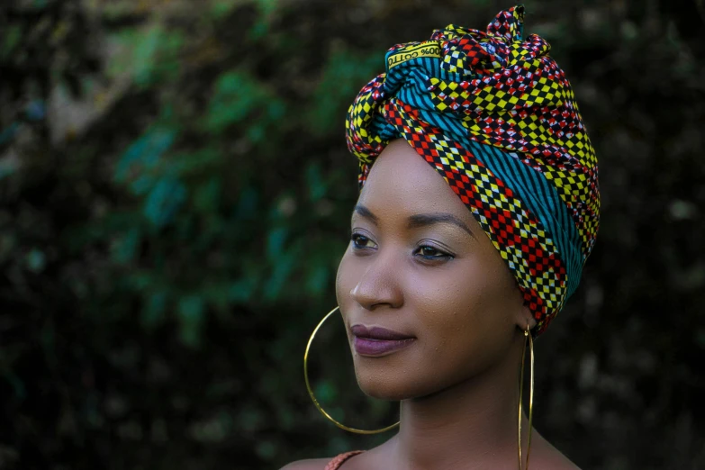 a woman with an intricate hair tie and hoop earrings