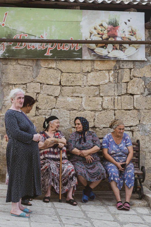 group of women siting next to each other on bench