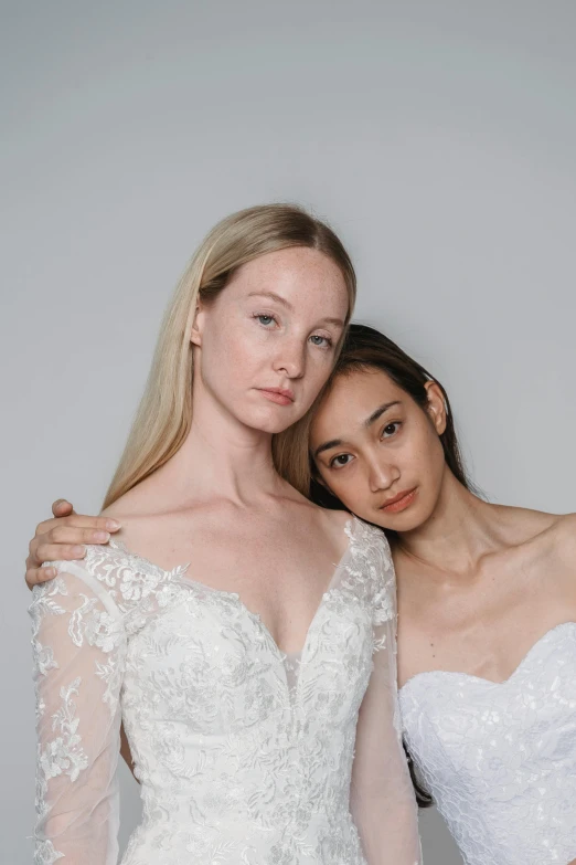 two brides in different poses and wearing a long sleeved gown