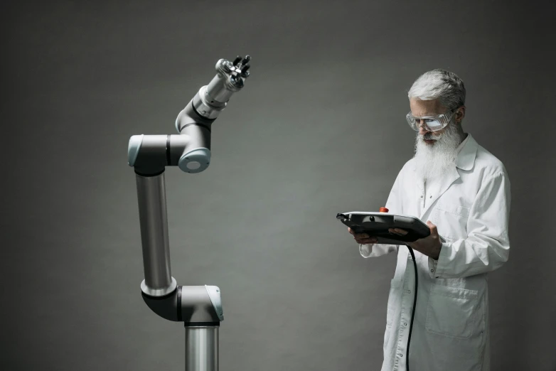 a man standing in front of a robot holding a tablet