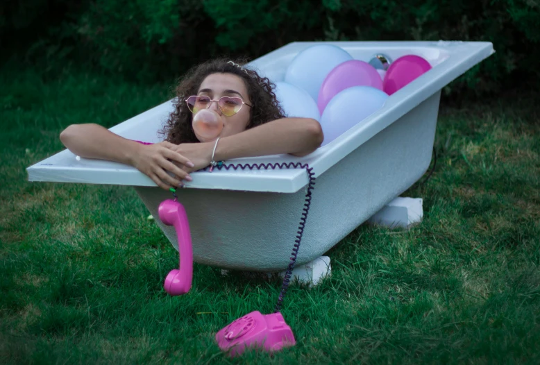 a girl in a bathtub is holding her head out