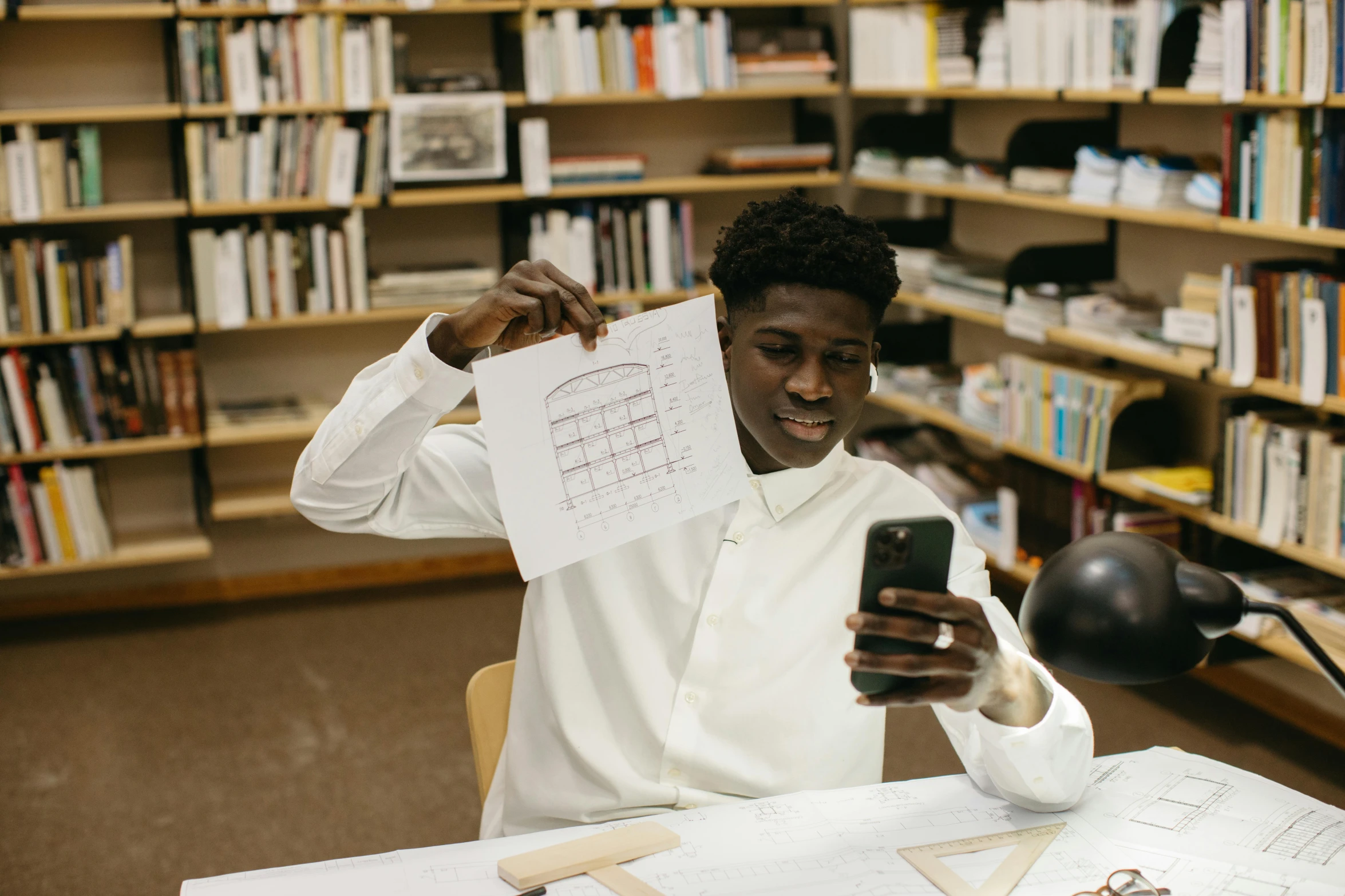 a man is holding papers and looking at his cell phone