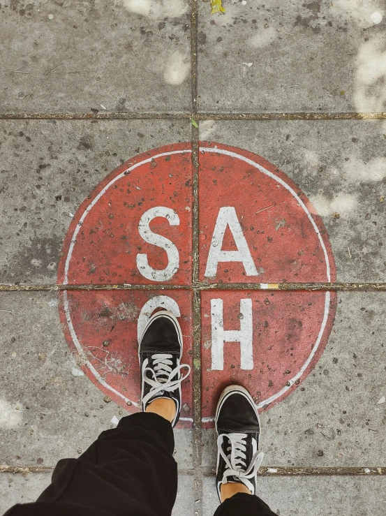 a person standing in front of an ash stop sign