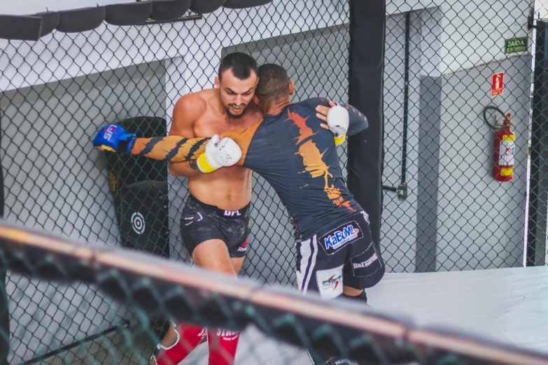 two men are fighting in an amateur boxing ring