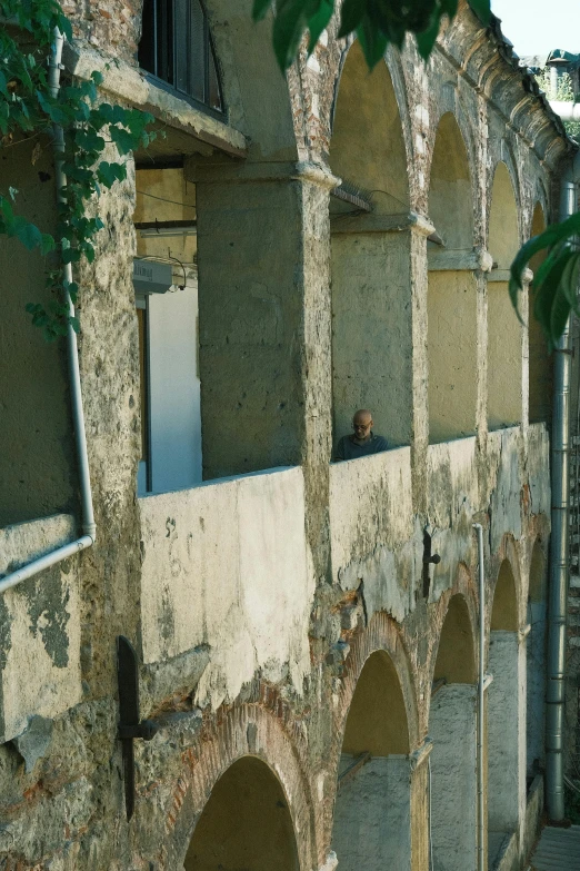 an old wall with archways near buildings